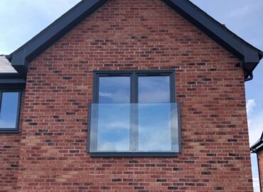 juliet balcony on the side of a brick house